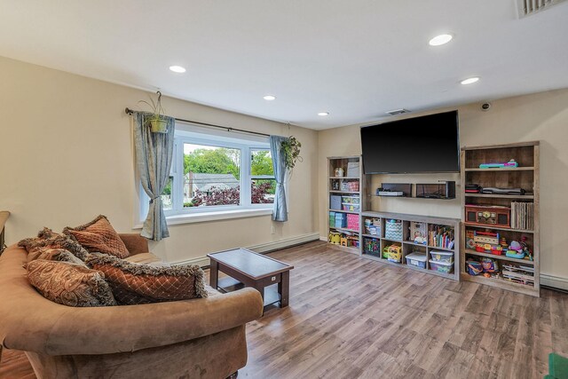 living room featuring wood finished floors, recessed lighting, a baseboard heating unit, and baseboards