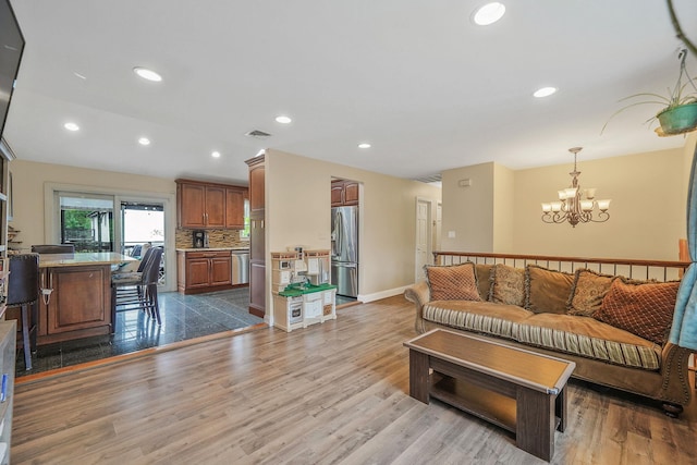 living room featuring a chandelier, wood finished floors, recessed lighting, and baseboards