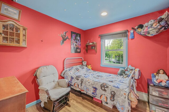 bedroom with recessed lighting, wood finished floors, and baseboards