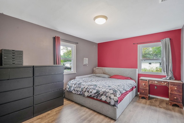 bedroom with multiple windows and wood-type flooring
