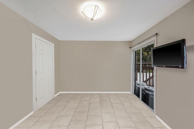 spare room featuring baseboards and light tile patterned floors
