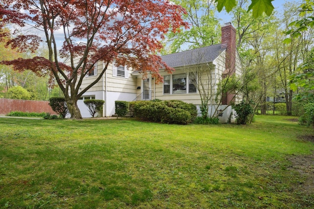 view of home's exterior with a chimney and a lawn