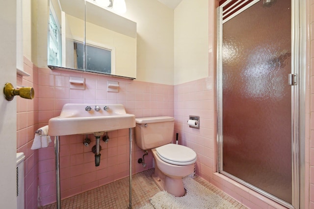 full bathroom featuring a shower stall, tile walls, wainscoting, and toilet