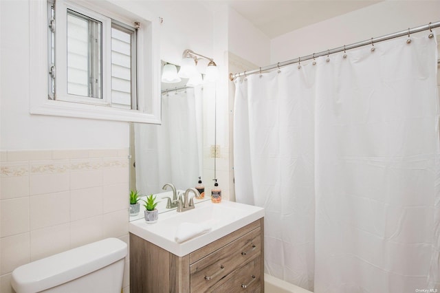 full bathroom with tile walls, vanity, and toilet