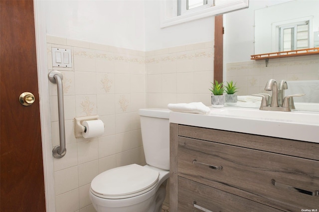 half bath featuring tile walls, vanity, and toilet