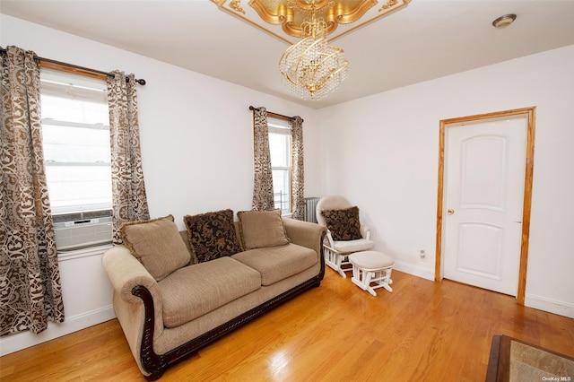living room with a healthy amount of sunlight, light wood finished floors, and a notable chandelier