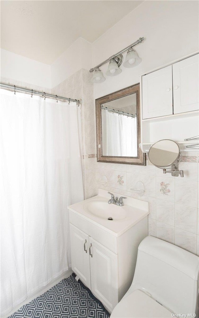 bathroom with vanity, curtained shower, toilet, and tile walls