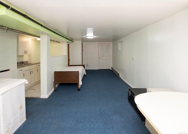 unfurnished bedroom featuring ensuite bath, baseboard heating, and dark colored carpet