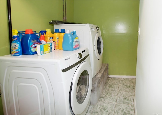 washroom with laundry area, baseboards, independent washer and dryer, and light tile patterned floors