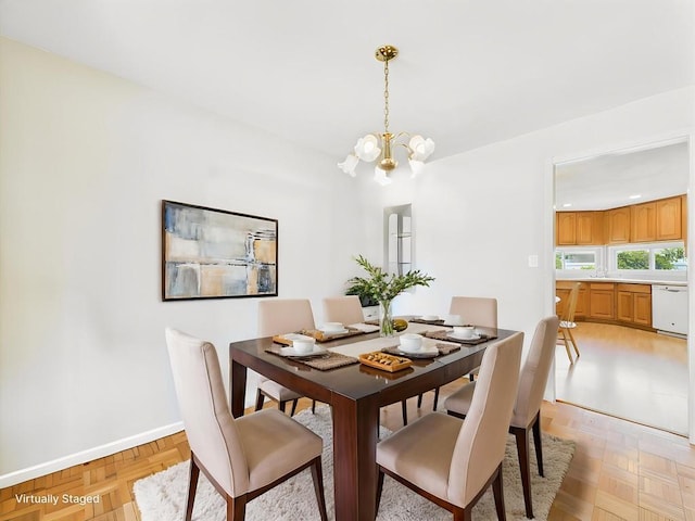 dining area featuring a chandelier and baseboards