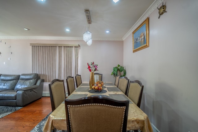 dining room featuring wood finished floors, baseboard heating, ornamental molding, and recessed lighting