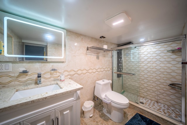 full bathroom featuring vanity, toilet, tile walls, and a shower stall