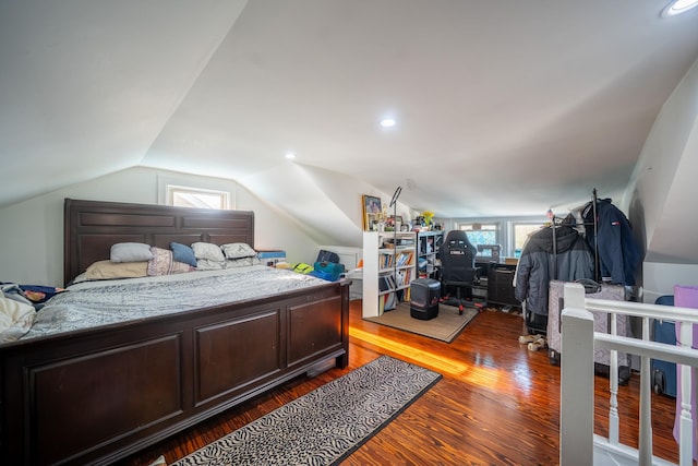 bedroom featuring multiple windows, vaulted ceiling, and wood finished floors