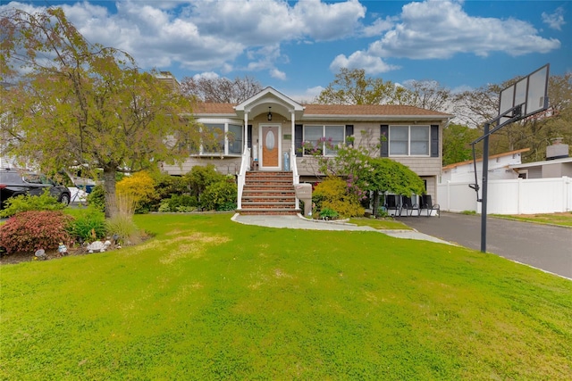 view of front of property with a front lawn and fence
