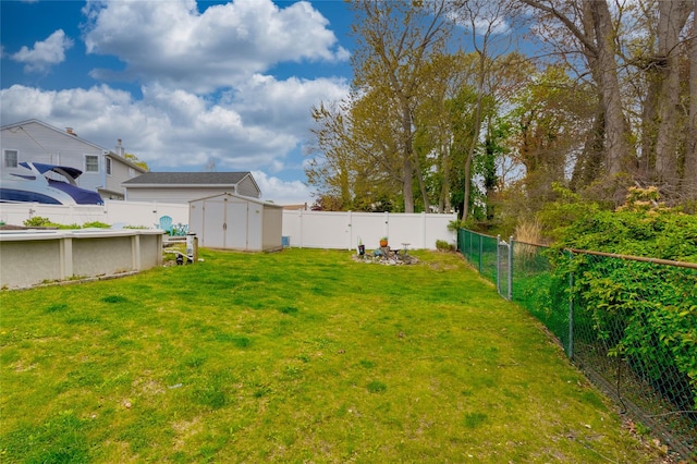 view of yard featuring an outbuilding, a pool, a fenced backyard, and a storage unit