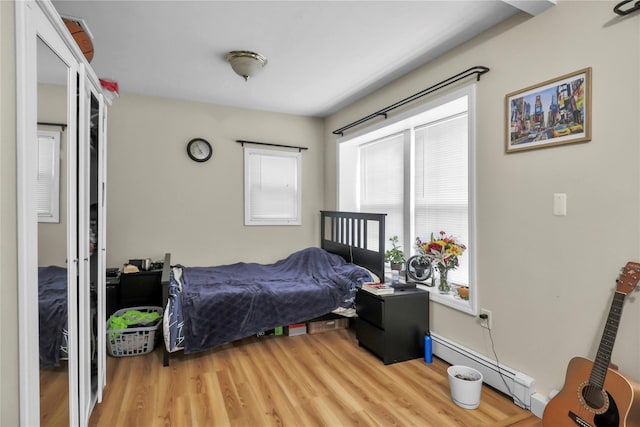 bedroom featuring light wood-style floors and baseboard heating