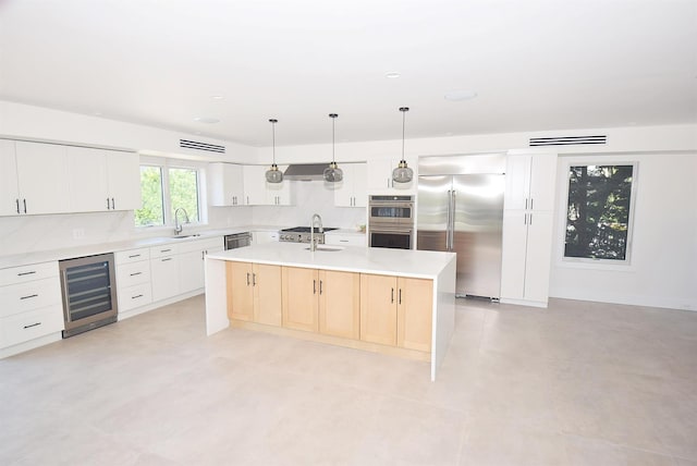 141 Flamingo St, Atlantic Beach, NY 11509 - kitchen featuring stainless steel appliances, beverage cooler, an island with sink, a sink, and light countertops