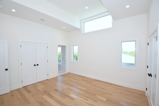 141 Flamingo St, Atlantic Beach, NY 11509 - unfurnished bedroom with light wood finished floors, a towering ceiling, recessed lighting, and baseboards