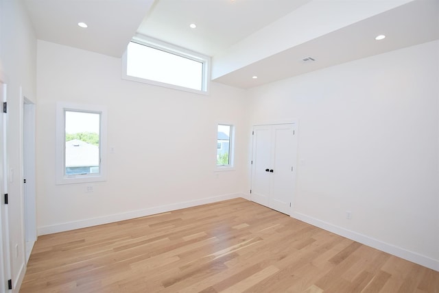 141 Flamingo St, Atlantic Beach, NY 11509 - empty room with light wood-type flooring, a high ceiling, baseboards, and recessed lighting