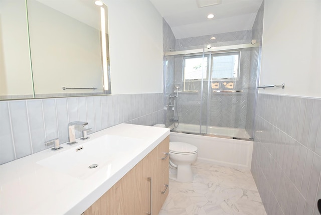 141 Flamingo St, Atlantic Beach, NY 11509 - full bath with wainscoting, marble look tiles, toilet, vanity, and combined bath / shower with glass door