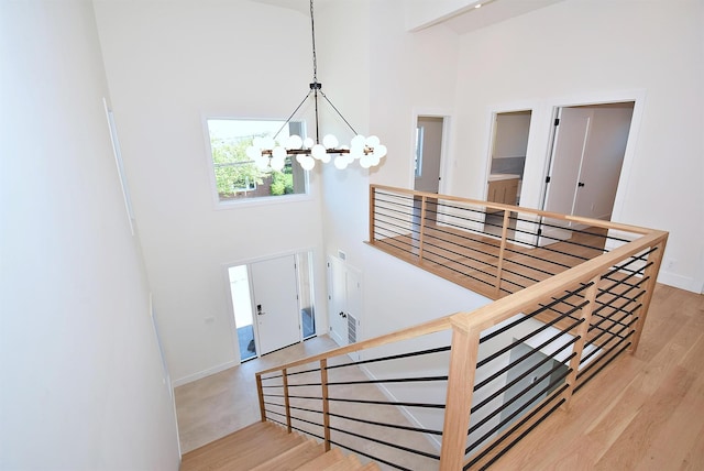 141 Flamingo St, Atlantic Beach, NY 11509 - stairway with a high ceiling, a chandelier, wood finished floors, and baseboards