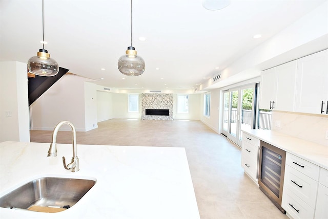 141 Flamingo St, Atlantic Beach, NY 11509 - kitchen with wine cooler, a sink, white cabinets, light countertops, and recessed lighting