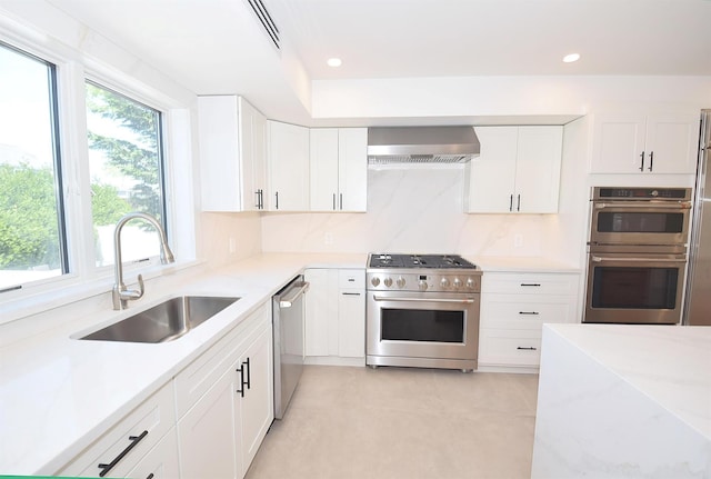 141 Flamingo St, Atlantic Beach, NY 11509 - kitchen featuring stainless steel appliances, wall chimney exhaust hood, a sink, white cabinetry, and recessed lighting