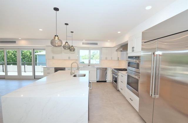 141 Flamingo St, Atlantic Beach, NY 11509 - kitchen with high end appliances, a sink, backsplash, white cabinetry, and recessed lighting