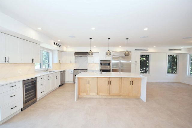 141 Flamingo St, Atlantic Beach, NY 11509 - kitchen with beverage cooler, stainless steel appliances, a sink, decorative backsplash, and a center island with sink