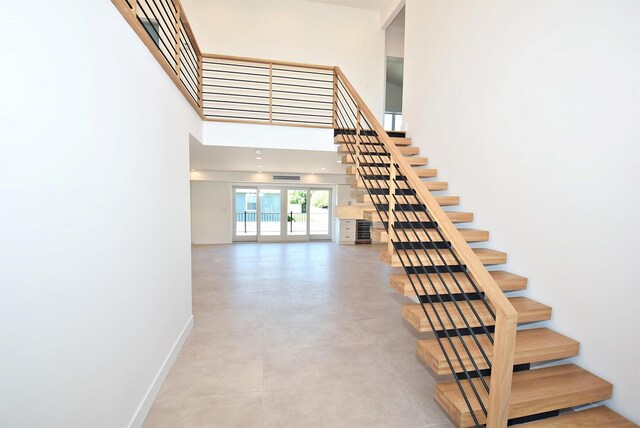 141 Flamingo St, Atlantic Beach, NY 11509 - stairs featuring baseboards, a towering ceiling, and concrete floors