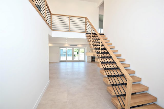 141 Flamingo St, Atlantic Beach, NY 11509 - staircase featuring a towering ceiling and concrete floors