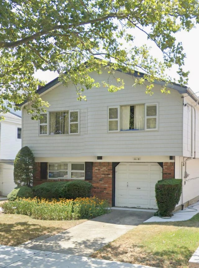 160-38 85th St, Howard Beach, NY 11414 - view of front facade featuring concrete driveway, brick siding, and a garage