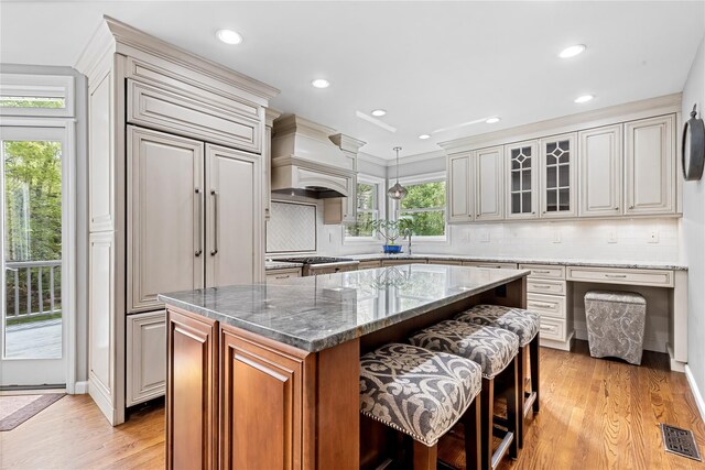 26 Garrity Blvd, Brewster, NY 10509 - kitchen with light wood-style flooring, visible vents, a kitchen breakfast bar, premium range hood, and backsplash