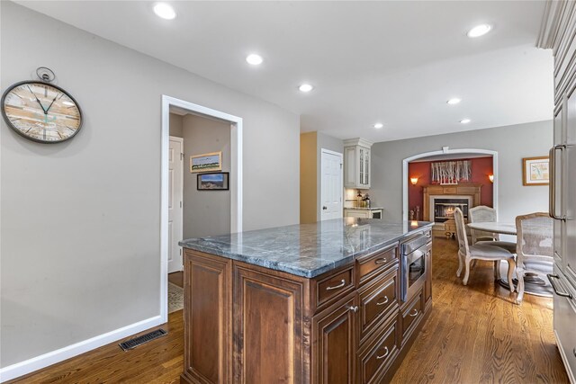 26 Garrity Blvd, Brewster, NY 10509 - kitchen featuring dark stone countertops, visible vents, stainless steel microwave, dark wood-type flooring, and a kitchen island