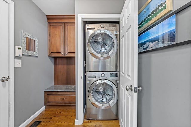 26 Garrity Blvd, Brewster, NY 10509 - clothes washing area with baseboards, visible vents, stacked washer and clothes dryer, wood finished floors, and laundry area