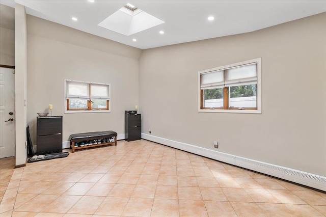unfurnished room featuring a skylight, light tile patterned floors, recessed lighting, baseboards, and baseboard heating