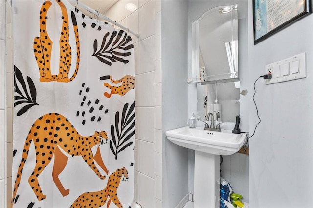 bathroom featuring a shower with shower curtain and a sink