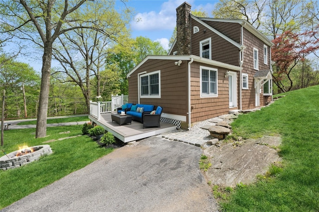 90 Shingle House Rd, Millwood, NY 10546 - view of side of property with a wooden deck, a chimney, an outdoor living space with a fire pit, and a lawn