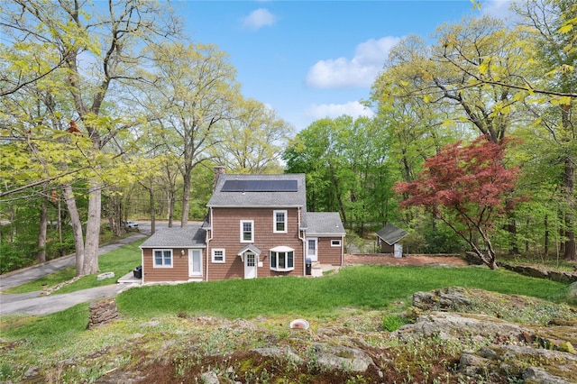 90 Shingle House Rd, Millwood, NY 10546 - view of front of property with entry steps, solar panels, a chimney, a front yard, and roof with shingles
