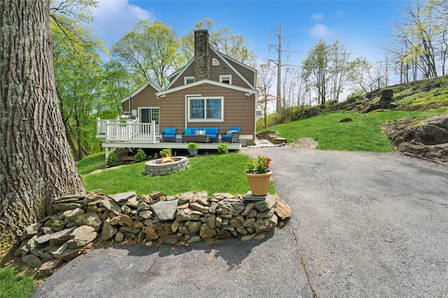 90 Shingle House Rd, Millwood, NY 10546 - back of property featuring a wooden deck, a chimney, a lawn, driveway, and an outdoor living space with a fire pit