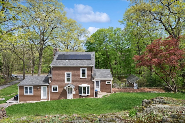 90 Shingle House Rd, Millwood, NY 10546 - colonial inspired home featuring solar panels, a shingled roof, a chimney, and a front lawn