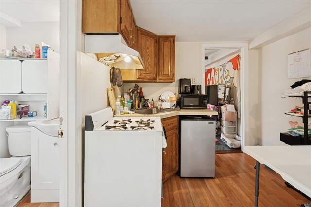 90 Shingle House Rd, Millwood, NY 10546 - kitchen featuring black microwave, gas range gas stove, under cabinet range hood, brown cabinetry, and light wood finished floors