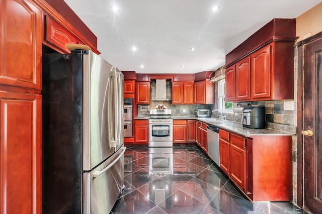 kitchen featuring stainless steel appliances, granite tiled floors, a sink, backsplash, and recessed lighting