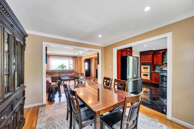 dining area with baseboards, crown molding, recessed lighting, and light wood-style flooring