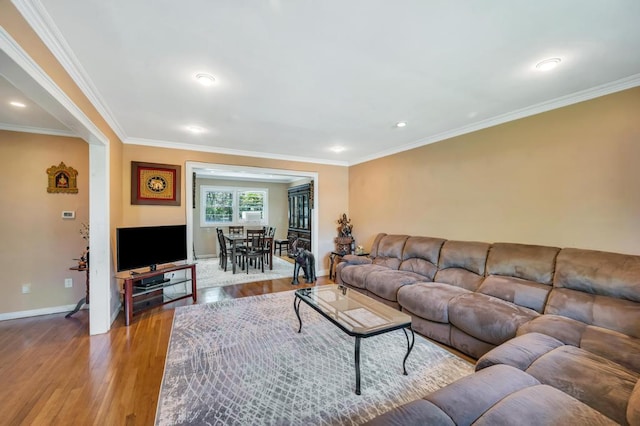 living room featuring wood finished floors, baseboards, crown molding, and recessed lighting
