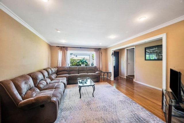 living room featuring wood finished floors, ornamental molding, baseboards, and recessed lighting