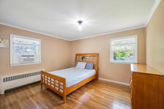 bedroom featuring radiator, crown molding, light wood finished floors, baseboards, and cooling unit