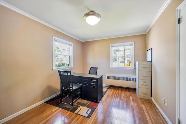 office area featuring radiator, plenty of natural light, wood-type flooring, crown molding, and baseboards