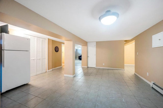 unfurnished living room featuring baseboard heating, tile patterned floors, and baseboards