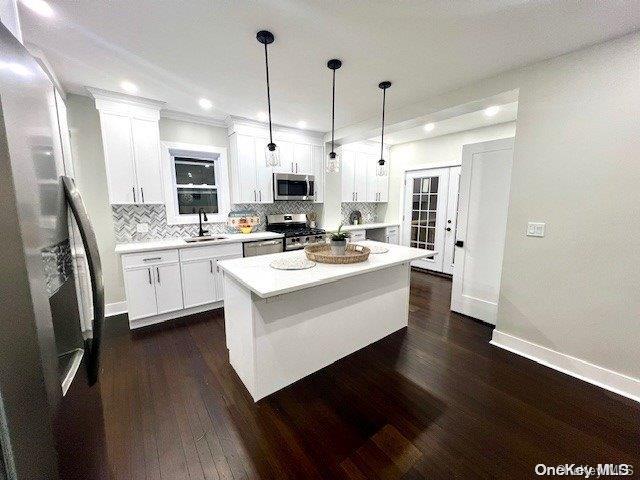 2906 Oceanside Rd, Oceanside, NY 11572 - kitchen featuring stainless steel appliances, a sink, white cabinetry, backsplash, and recessed lighting